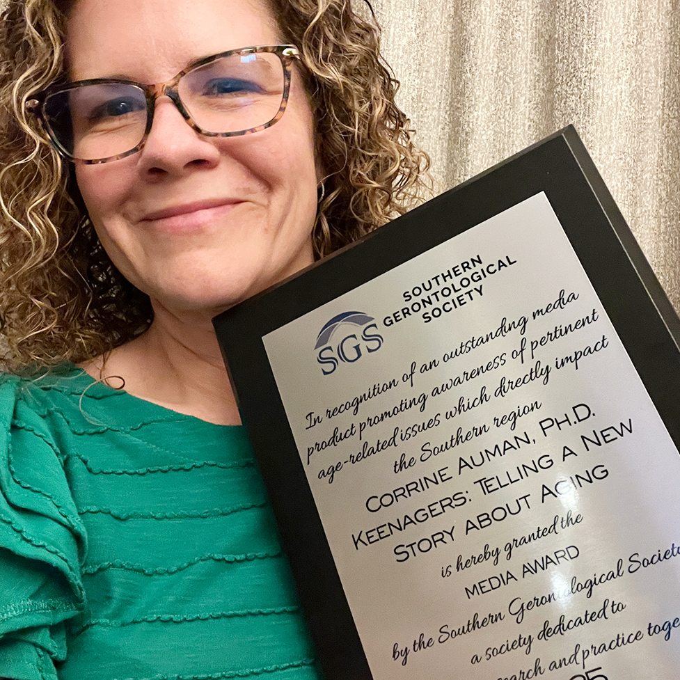 Dr. Corinne Auman holding the Media Award by the Southern Gerontological Society